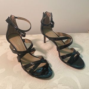 Black strappy sandals. Zip back. Fastens around ankle.